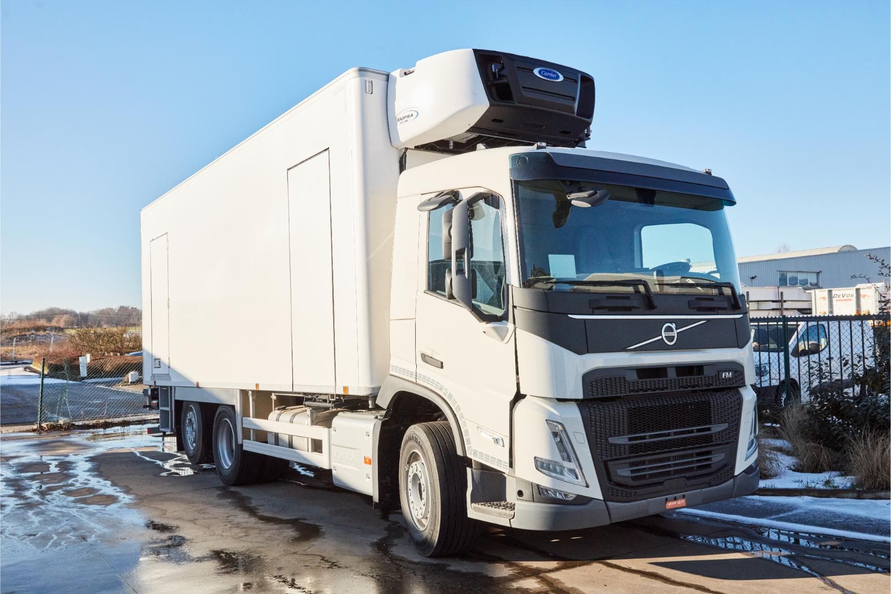 Een witte Volvo FM koelwagen met Carrier Supra-koelgroep op het dak, buiten opgesteld