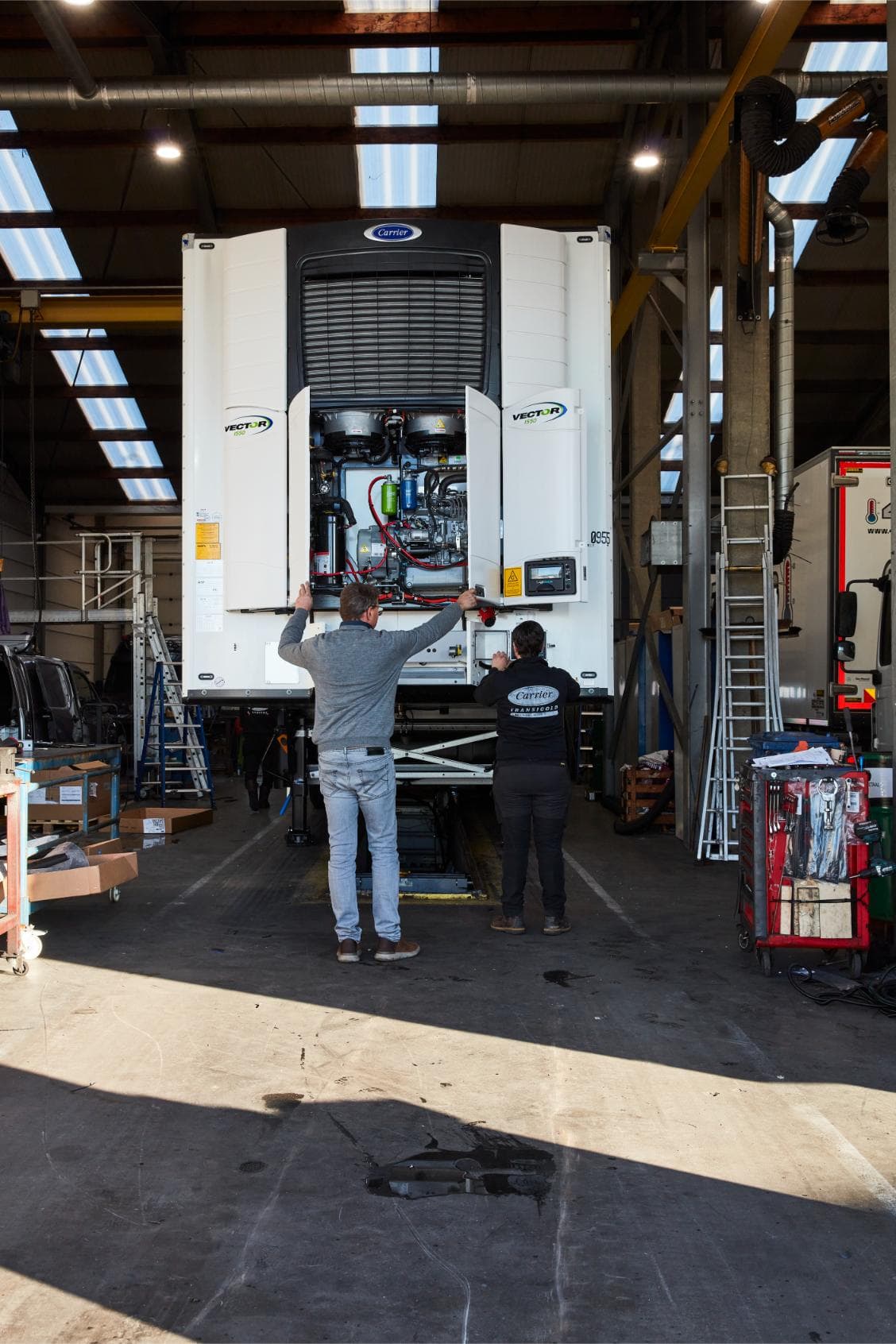 Twee technici van Westcool aan een geopende Carrier Vector 1550 in de werkplaats