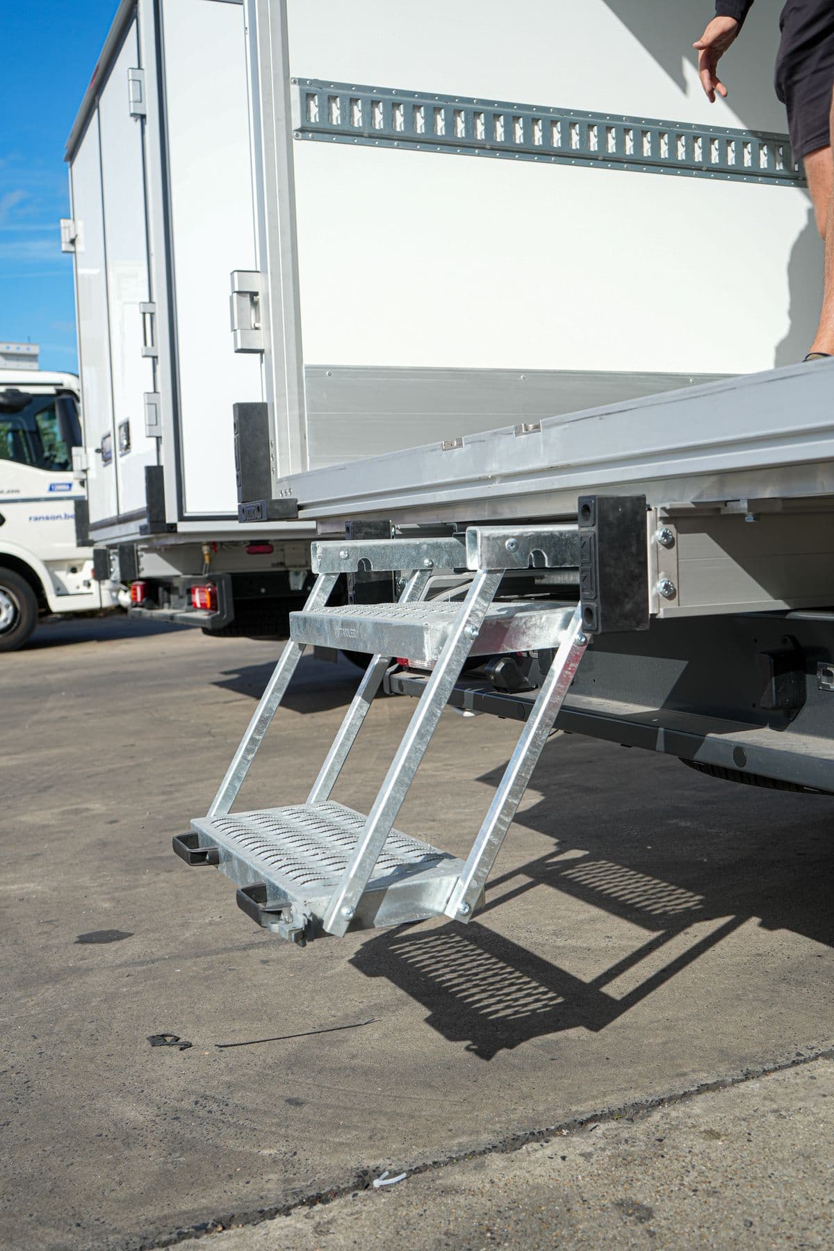 De uitklapbare opstap aan de achterdeur van een Isocar box