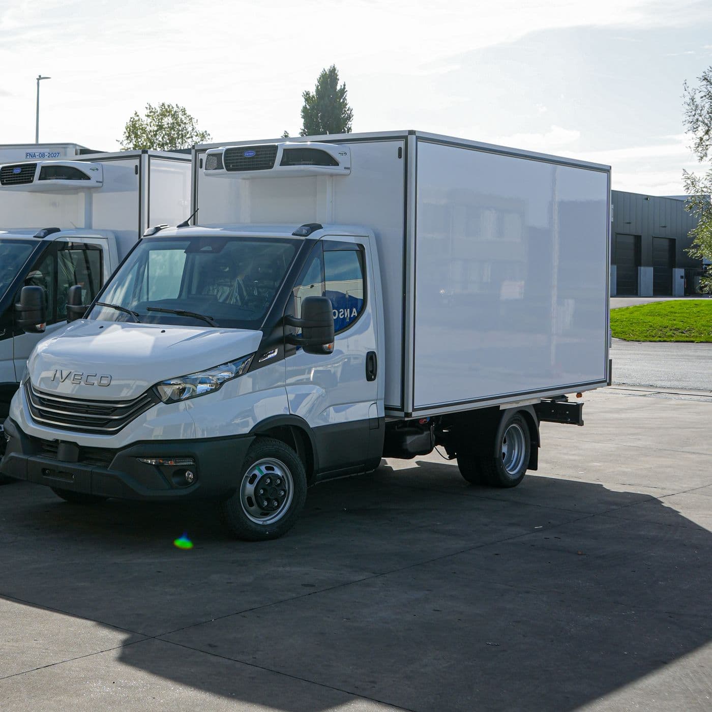 Deux Iveco Daily blancs avec une caisse Isocar, vus de trois quarts avant